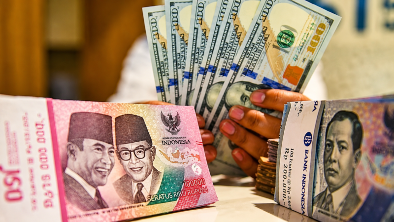 Tumpukan uang rupiah dan dolar AS dalam ilustrasi pergerakan nilai tukar. Bank Indonesia menegaskan cadangan devisa nasional masih memadai untuk menjaga stabilitas ekonomi di tengah tekanan terhadap rupiah.