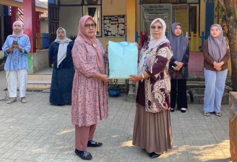 Kepala Sekolah SDN I Poyowa Besar Fatmiyati Makalalag SPd saat menyerahkan cenderamata perpisahan kepada Ibu Rosdaita Marada. Foto:Gnews86