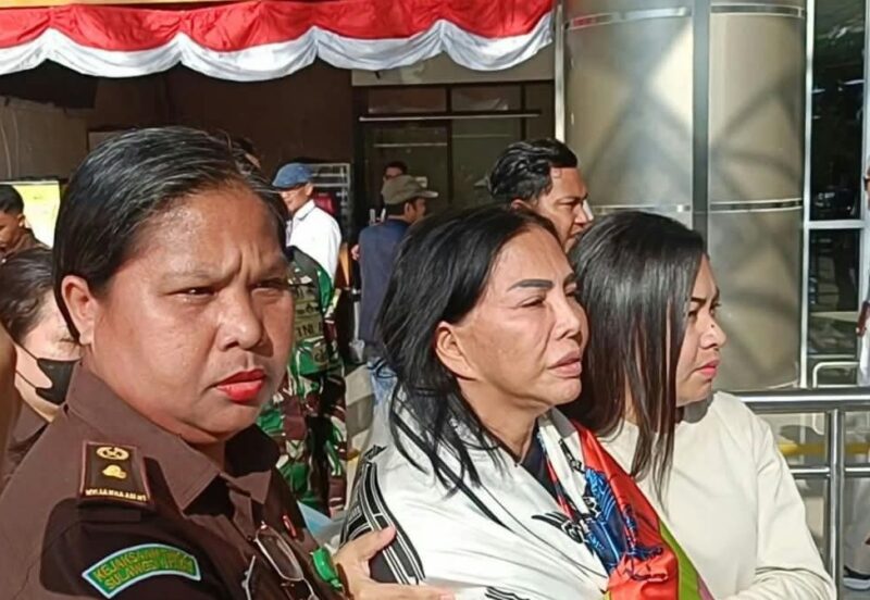 Mantan Bupati Minahasa Utara Vonnie Anneke Panambunan diapit petugas kejaksaan saat tiba di Bandara Sam Ratulangi Manado. (Foto/istimewa)