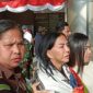 Mantan Bupati Minahasa Utara Vonnie Anneke Panambunan diapit petugas kejaksaan saat tiba di Bandara Sam Ratulangi Manado. (Foto/istimewa)