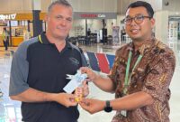 Salah satu penumpang pesawat yang mendapat sovenir cokelat dari petugas bandara (foto:istimewa)