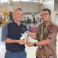 Salah satu penumpang pesawat yang mendapat sovenir cokelat dari petugas bandara (foto:istimewa)